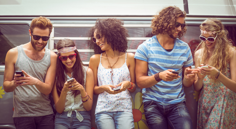 Hipster friends using their phones on a summers day Hipster friends using their phones on a summers day